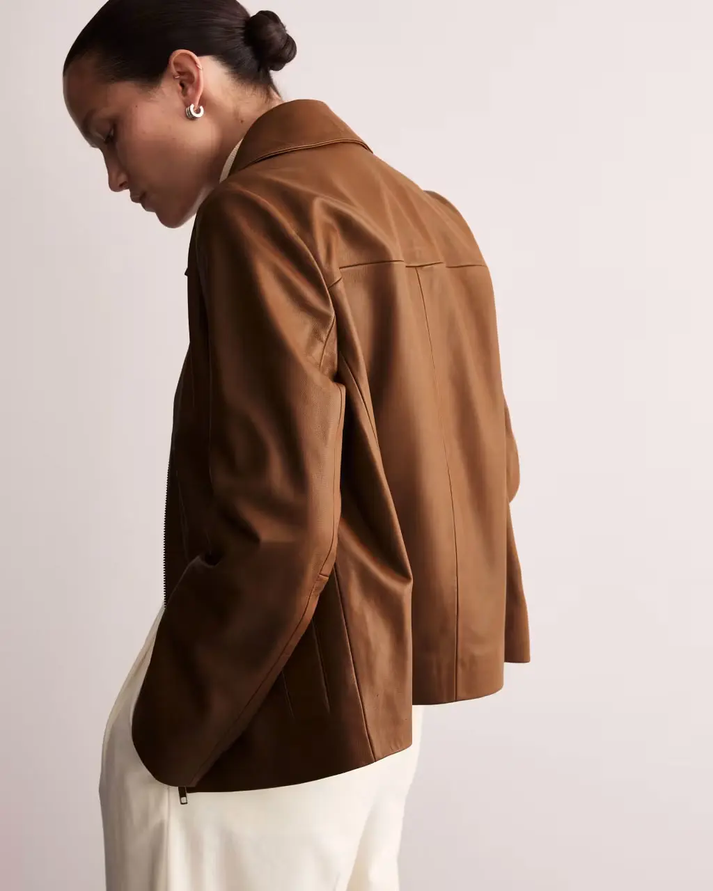 Woman wearing tan leather jacket by Jaeger at M&S