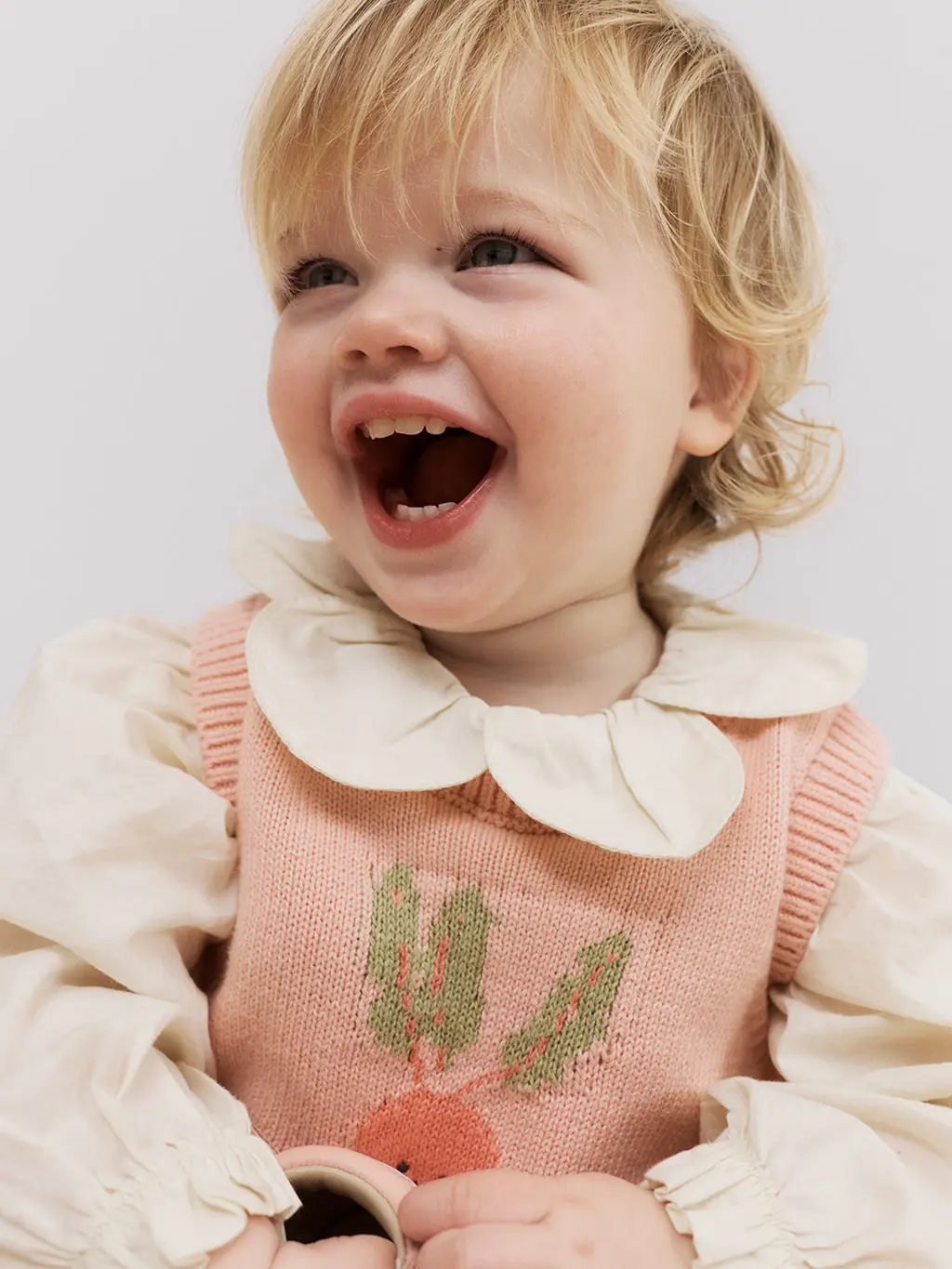 Little girl laughing in front of white background