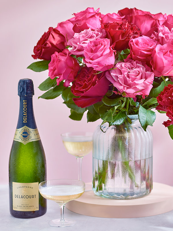 Bunch of pink roses with a bottle of champagne. Shop floral gift bundles