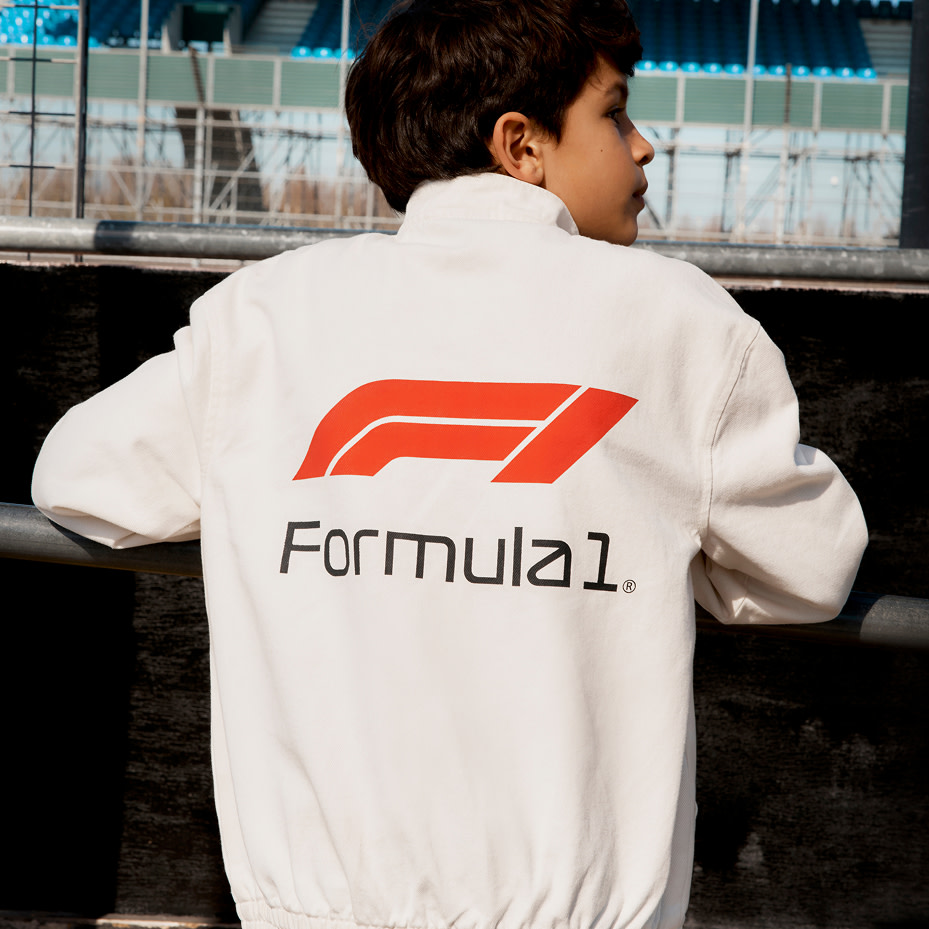 Boy wearing white top with Formula 1 logo 