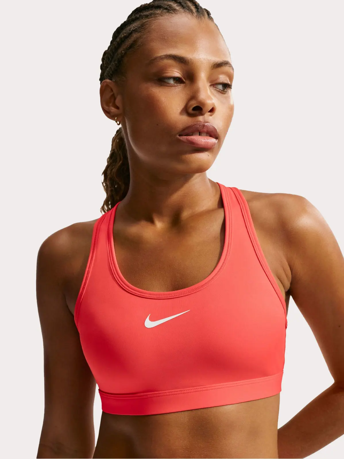 Woman wearing coral sports bra with Nike logo
