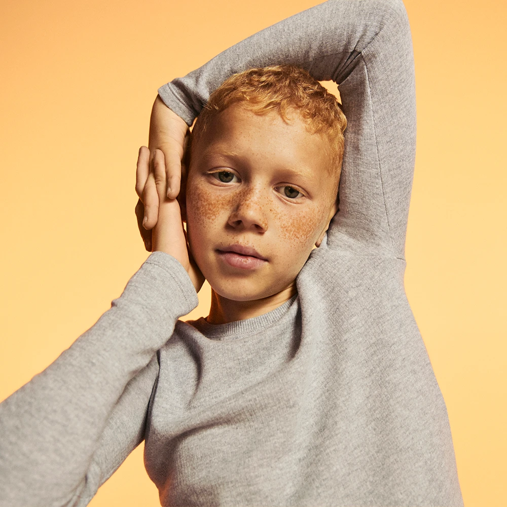Boy wearing grey long-sleeve thermal base layer top