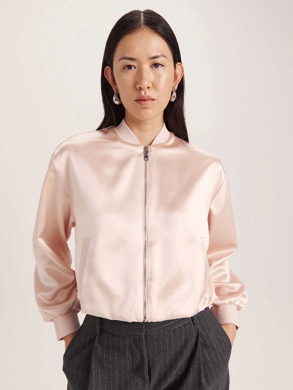 Woman wearing pink satin bomber jacket