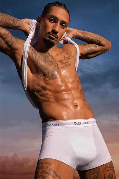 man wearing white boxers taking off vest