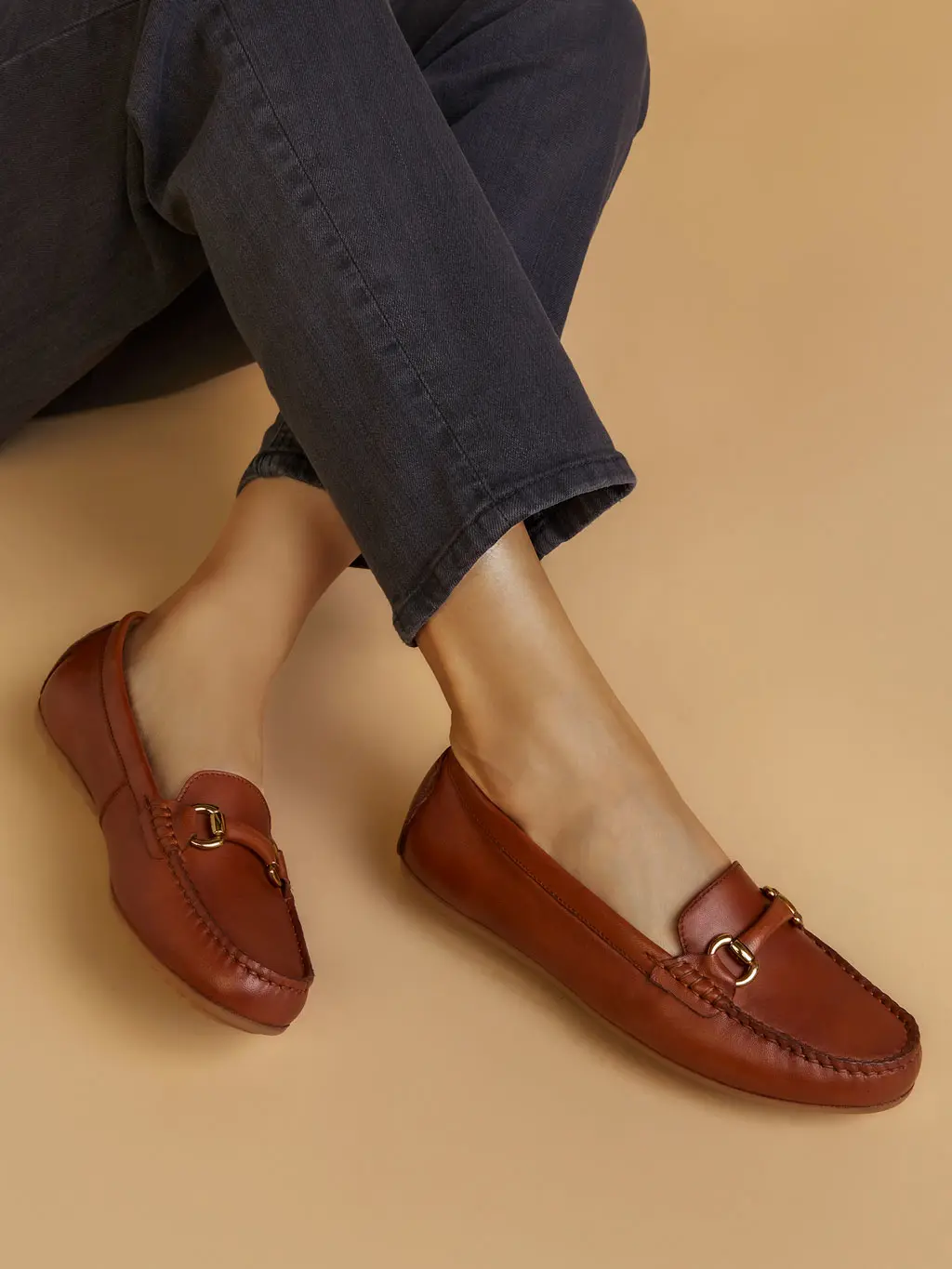 Woman wearing a pair of red loafers with black jeans