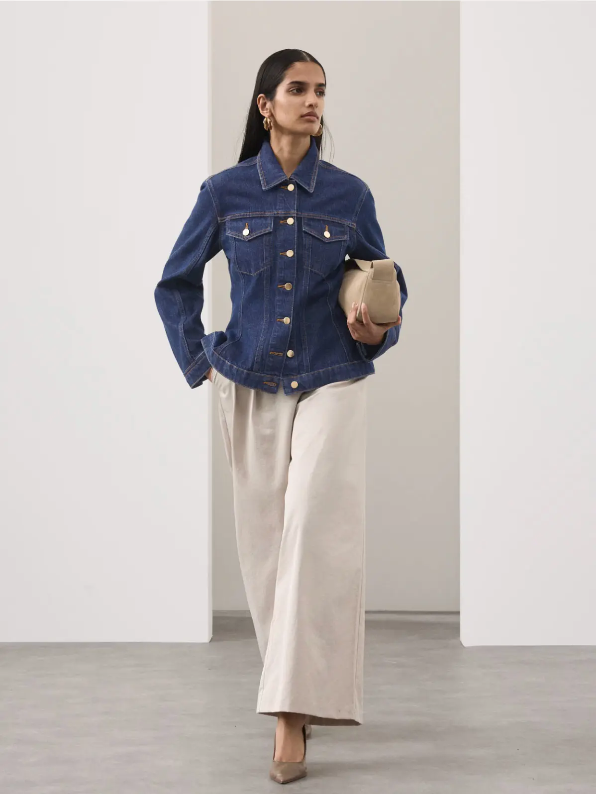Woman wearing denim jacket, wide-leg trousers and heels