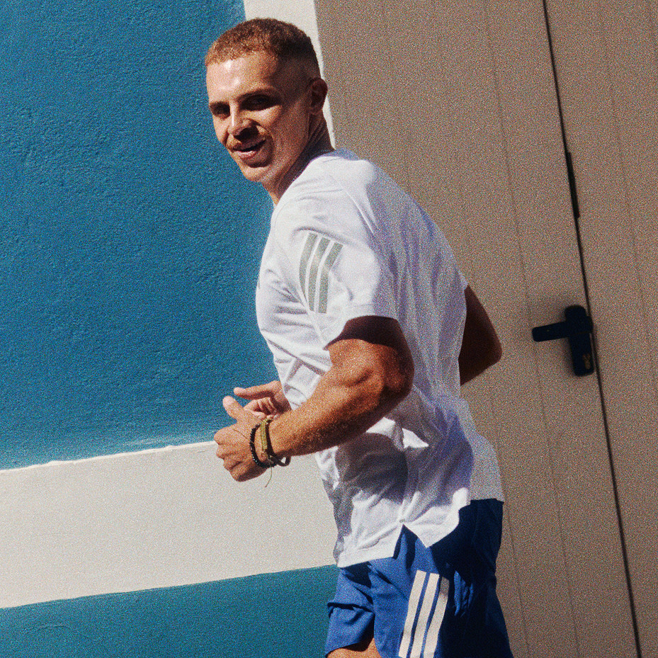 Man running in white T-shirt and blue shorts