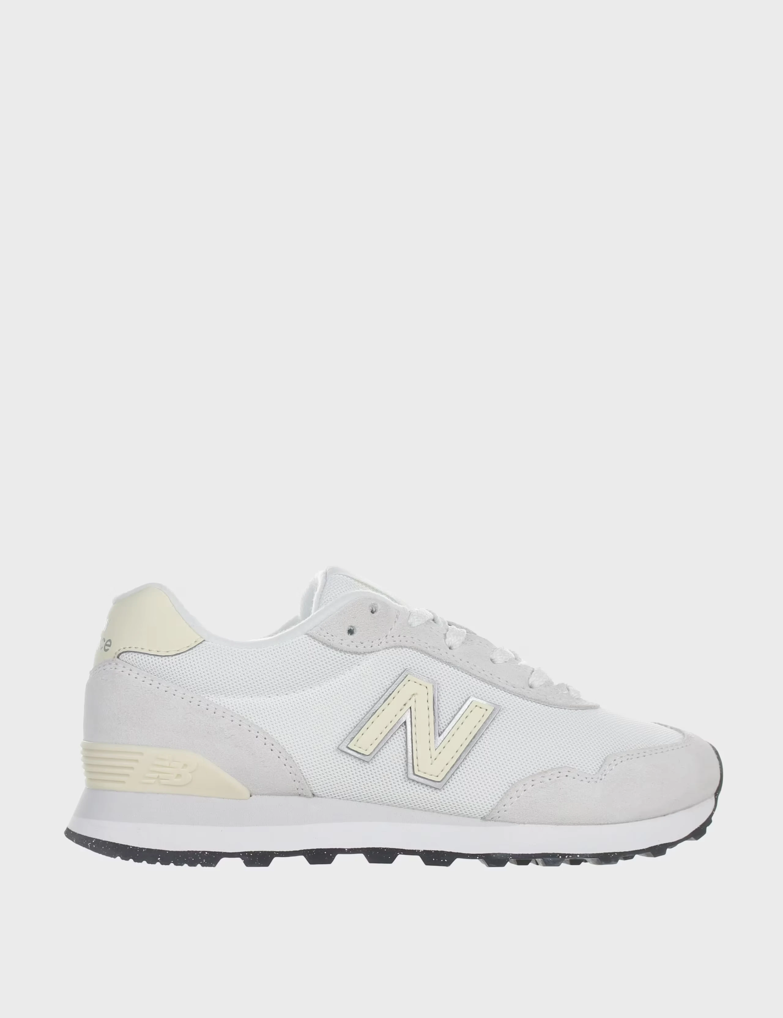 White New Balance trainers with a yellow logo and heel.