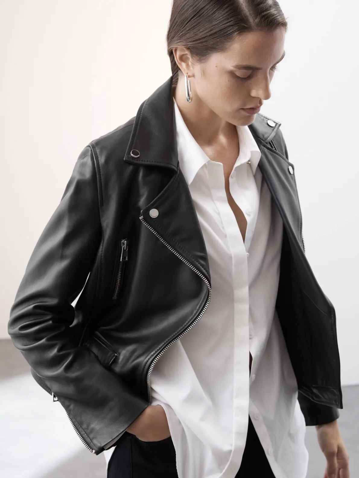 Woman wearing leather jacket over white shirt