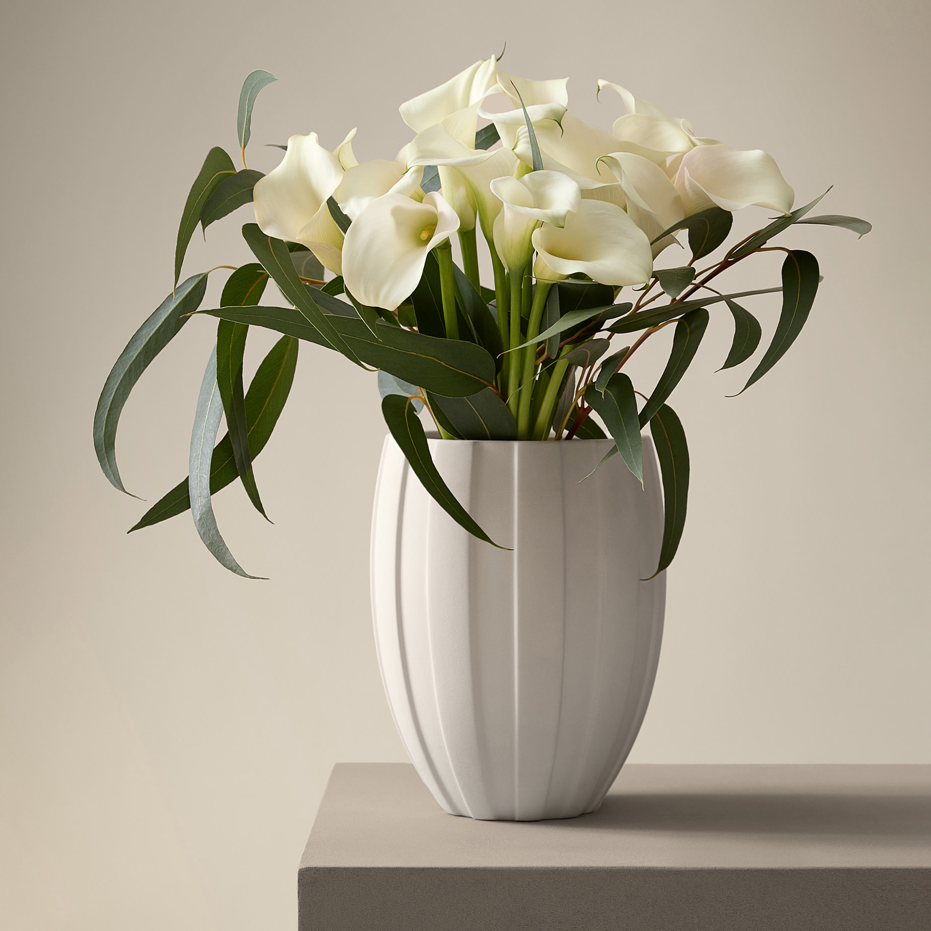 White calla lily bouquet created in collaboration with Kelly Hoppen, arranged in a white ceramic vase