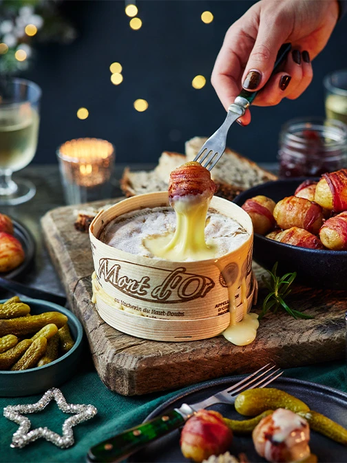 pigs in blankets dunked into oozy cheese fondue with pickles