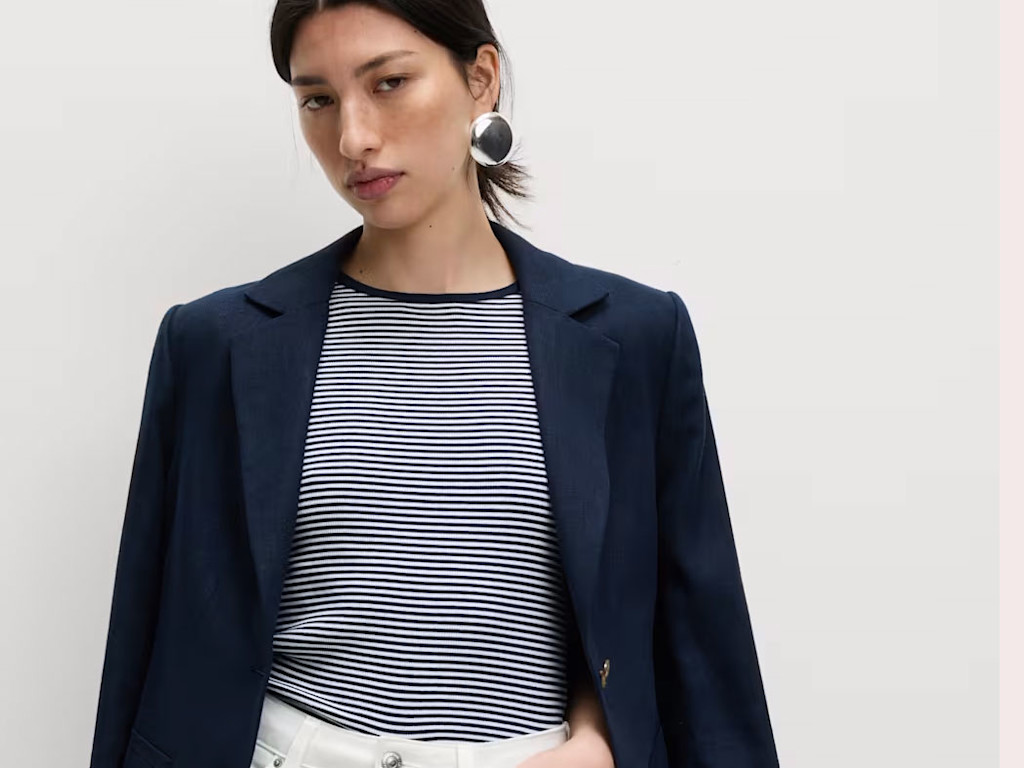 Woman wearing a striped T-shirt, navy black, white jeans and silver earrings