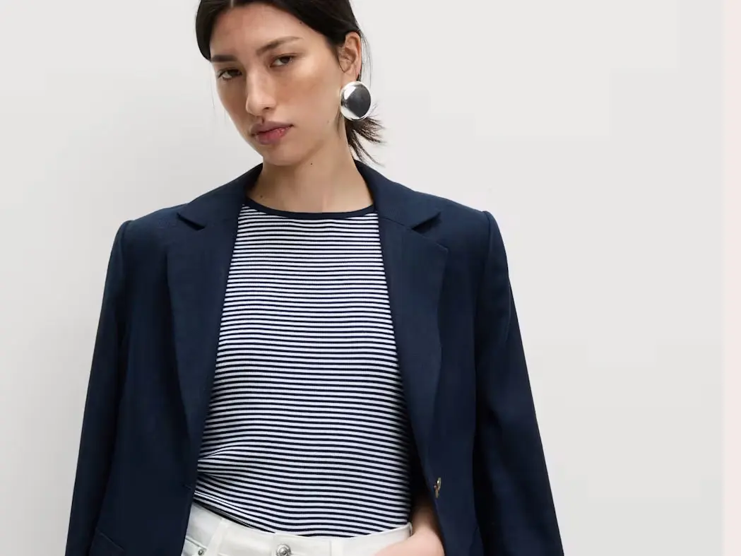 Woman wearing a striped T-shirt, navy black, white jeans and silver earrings