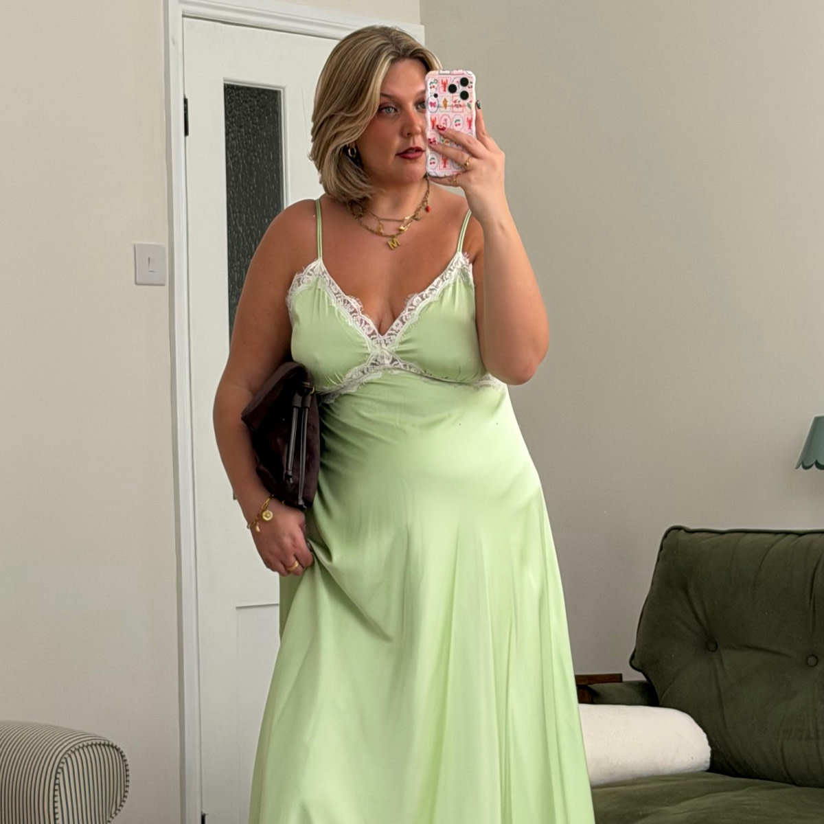 Woman wearing green slip dress with white lace detail 