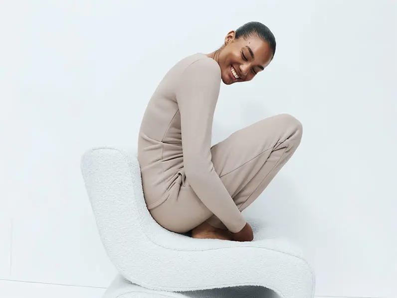 Woman wearing a light taupe thermal top with matching thermal leggings