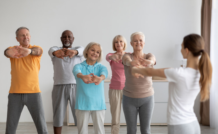 ISSA trainer giving a group exercise class with mature adult clients. 