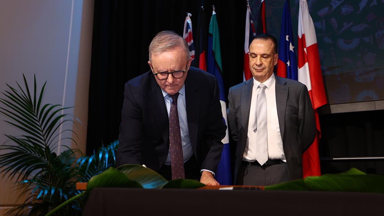 ARLC chairman Peter V'landys watches on as Anthony Albanese signs the partnership