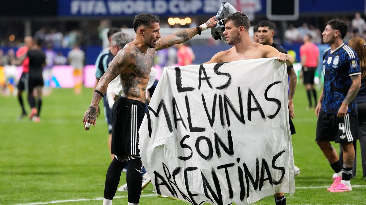 Argentina's Giovani Lo Celso and Nicolas Otamendi with the banner after the match with England
