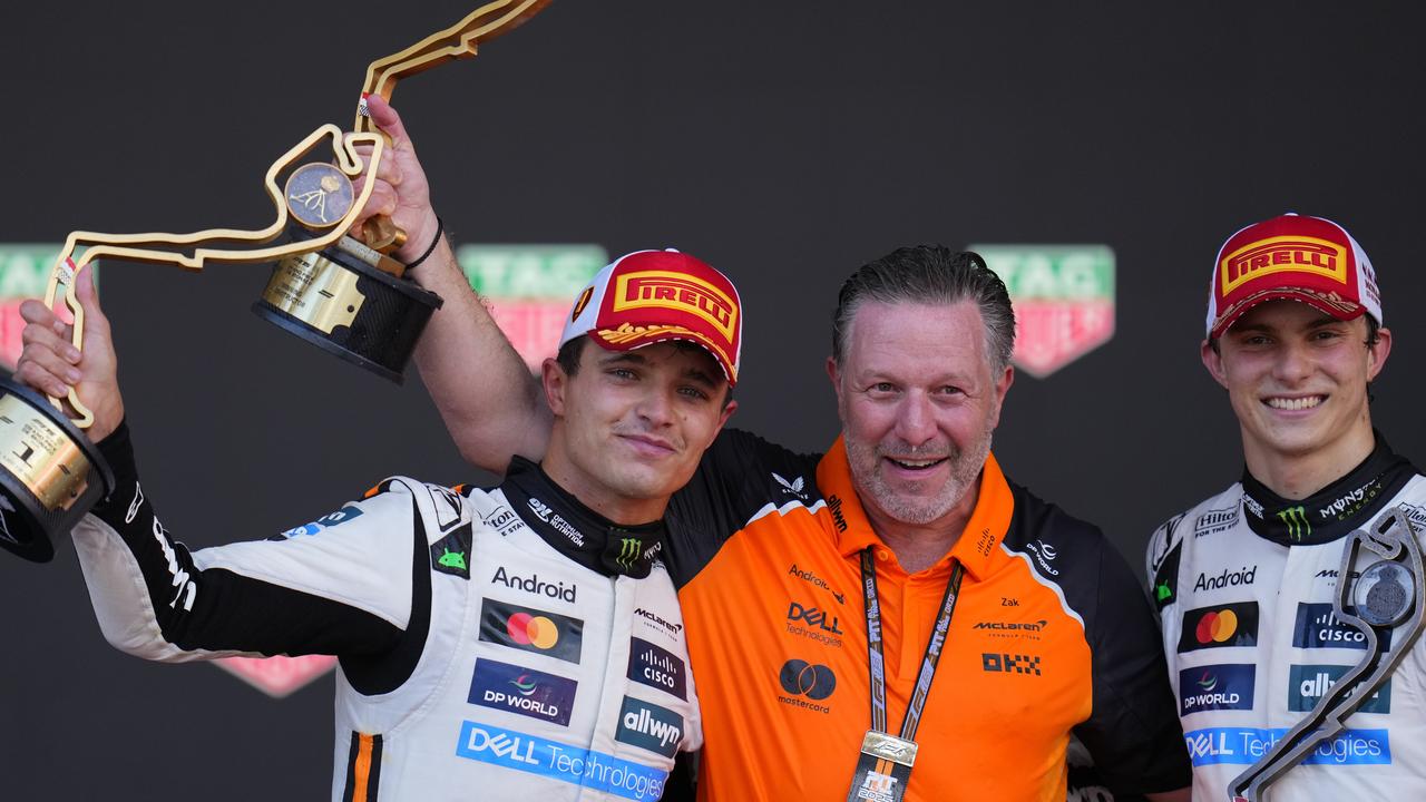 Lando Norris with McLaren chief Zak Brown and Oscar Piastri