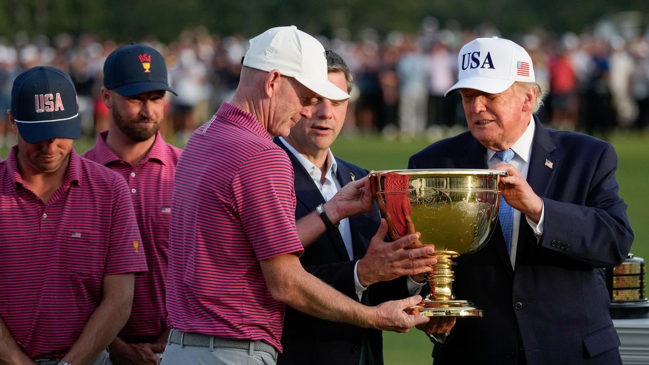 President Donald Trump hands the trophy to US team captain Brandt Snedeker
