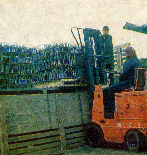 Archival image of forklift lifting pallet of juice bottles from 1977