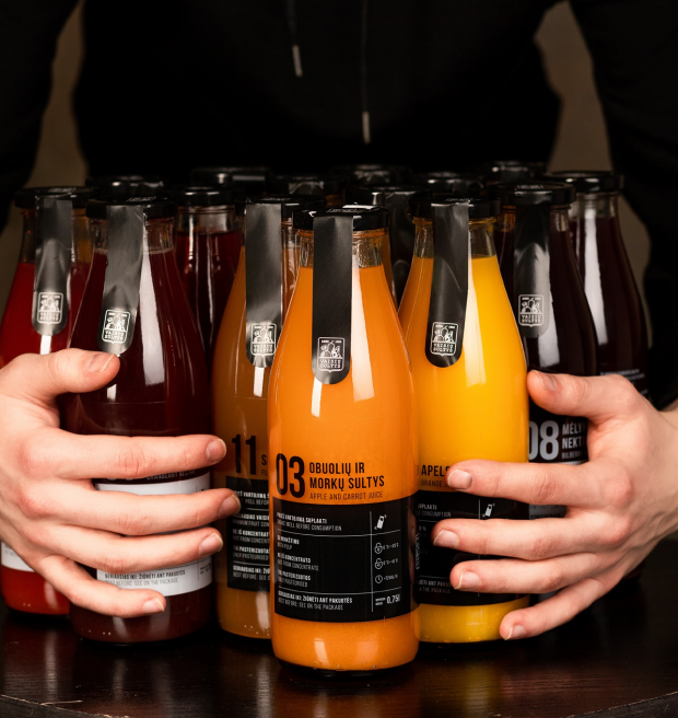 Hands grasping a lot of juices and nectars bottles