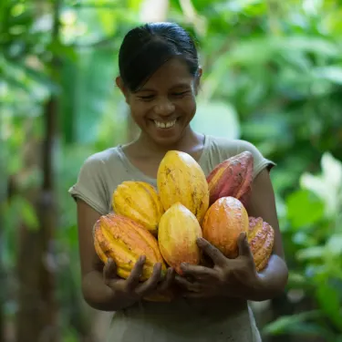 a woman holding a bunch of fruit in her hands