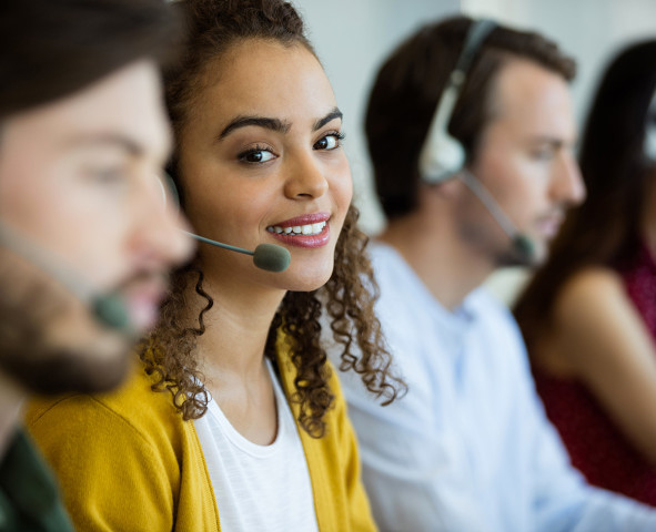 Telecare support advisor wearing a headset and smiling