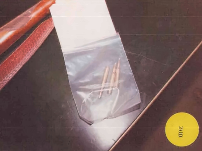 Three small brass cartridges in a clear plastic bag on a dark surface, yellow sticker "200"
