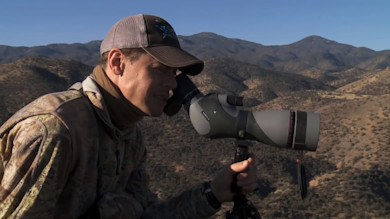 Steven Rinella using Vortex spotting scope over arid mountain hills