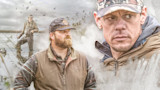 Hunters in marsh with flying ducks; one wading in water, one bearded man, one close-up face