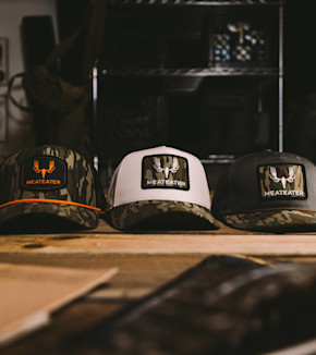 Three MeatEater caps with camo bills and front patches reading "MEATEATER"