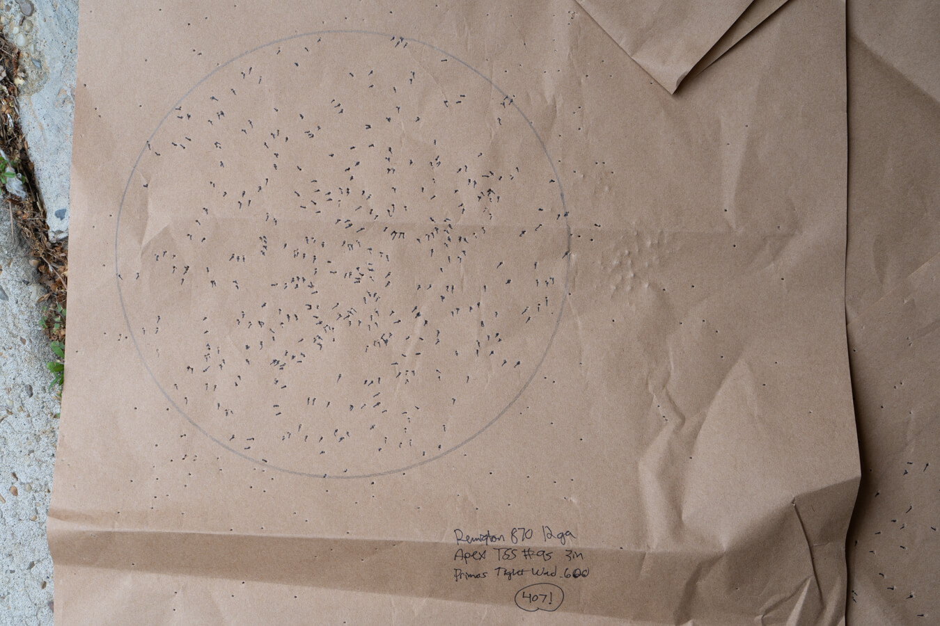 Paper shotgun target with dense pellet cluster inside circle; handwritten: Remington 870 12ga Apex TSS #5 .600 407