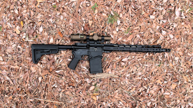 Black AR-style rifle with scope and detachable magazine
