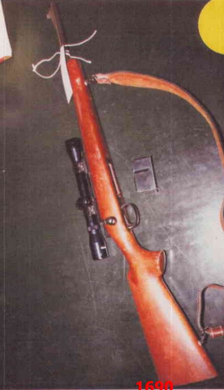 Bolt-action rifle with wooden stock, scope, detachable magazine and leather sling; visible text "1690"