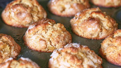 Apple-cider muffins in a dark muffin tin, sugar sprinkled on top