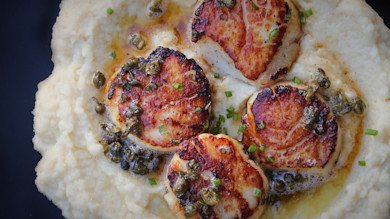 Seared scallops on celeriac puree with brown butter sauce, capers and chives