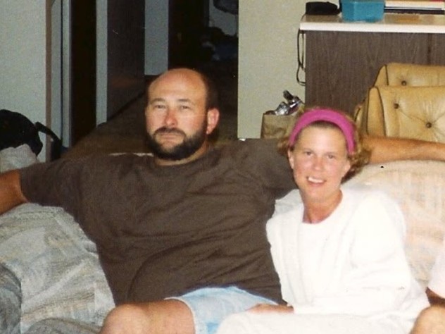 Bearded man and smiling woman sitting on a couch in a living room