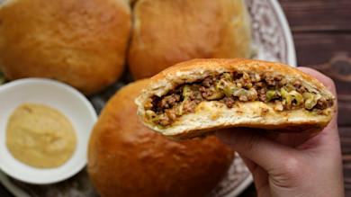 Runza sandwich half with seasoned ground beef and shredded cabbage in toasted bun