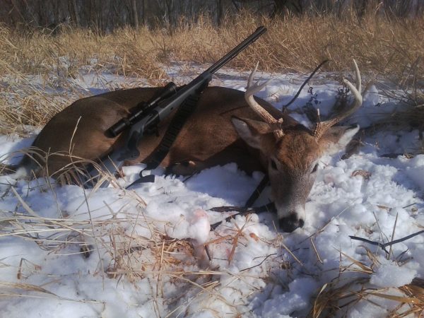 Brody Henderson happily shows a small whitetail buck killed. 