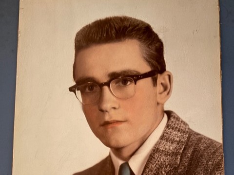 Young man in suit, tie and glasses in vintage studio portrait