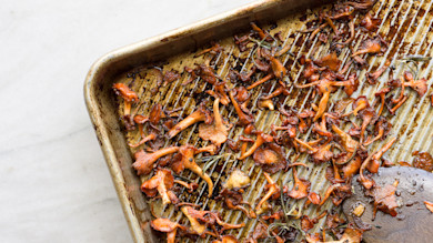 Crispy roasted chanterelles with rosemary on a browned metal rimmed baking sheet