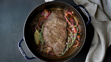 Balsamic-braised venison with red onions, thyme and bay leaf in pot labeled STAUB