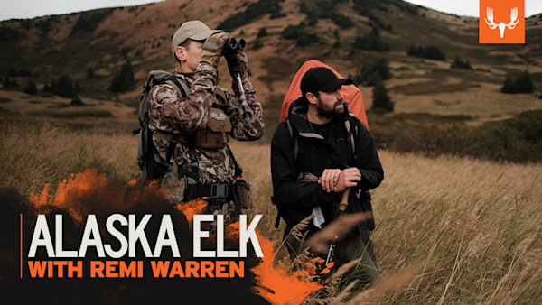 Two hunters in grassy Alaska hills, one using binoculars; overlay text "ALASKA ELK WITH REMI WARREN"