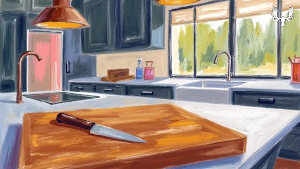 Cutting board with knife on kitchen island; sinks, window, and cabinets behind