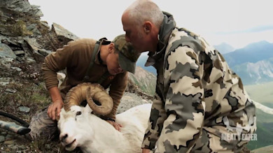 Two hunters kneel beside a large white ram on a rocky ridge, "MEAT EATER" overlay