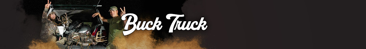 Two hunters by open pickup bed with harvested buck and gear, one flashing peace sign; text "Buck Truck"