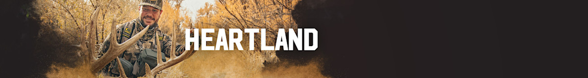 Hunter in camouflage holding elk antlers with "HEARTLAND" text overlay