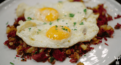 Corned elk hash with diced potatoes, two sunny-side-up eggs, chopped parsley