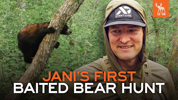 Janis Putelis smiling in First Lite cap with bear cub in tree; text overlay JANI'S FIRST BAITED BEAR HUNT